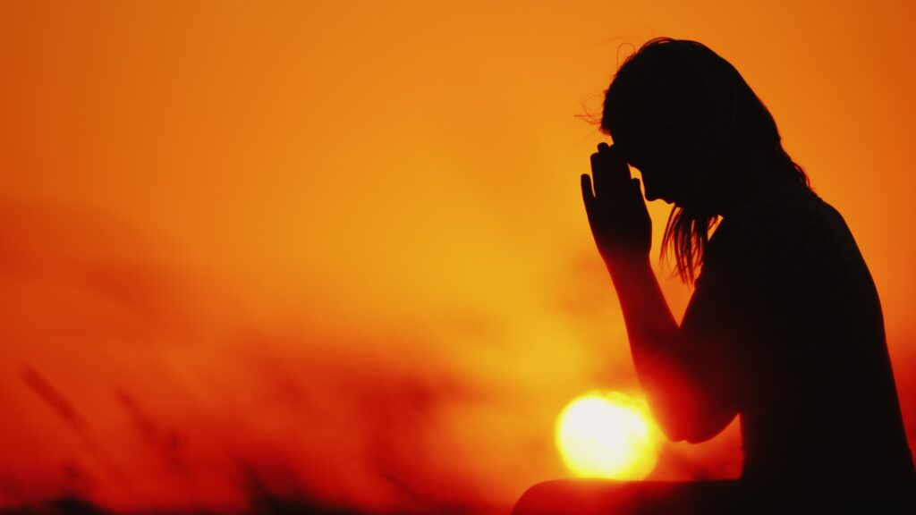 Silhouette of person praying